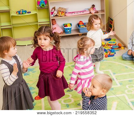 Group of little children dancing and claping in hands