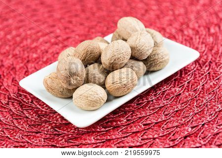 Pile Of Whole Dried Nutmeg Seed For Flavoring