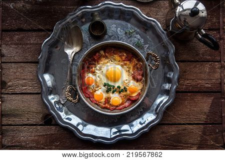 Turkish basturma with fried egg in a copper pan, rustic style.