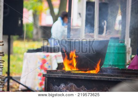 black caldron for cooking is at the stake