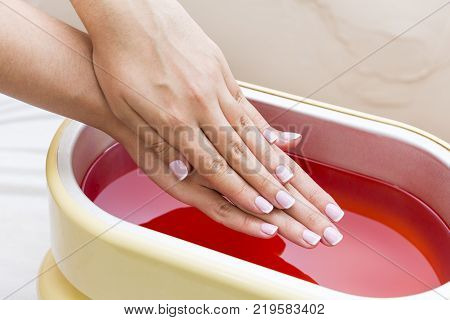 Process paraffin treatment of female hands in beauty salon