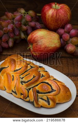 Still life of homemade pastries, sweet poppy pie on the background of fresh fruits, apples and grapes. Top View. Wooden rustic background