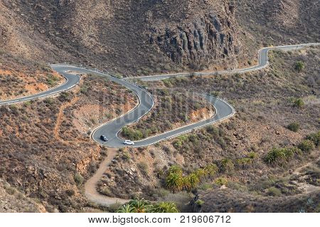Curved winding roads of Gran Canaria is feared by many, this is road with two cars driving in the majestic mountains at Gran Canaria, part of Canary Islands in Spain
