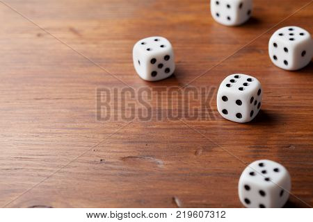Game of chance concept. White dice on rustic wooden board.