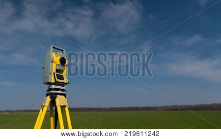 Surveyor equipment outdoors theodolite on tripod, blue sky in background