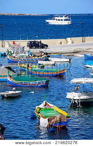 SAN PAWL, MALTA - APRIL 2, 2017 - Traditional Maltese Dghajsa fishing boats moored in the harbour with views towards the coastline San Pawl Malta Europe, April 2, 2017.