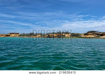 View of Cubagua island with rocks and tropical vegetation (Venezuela).
