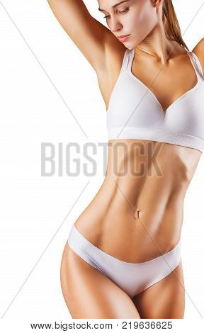 Sexy young woman with a sports body in white lingerie against a white background. Studio shot