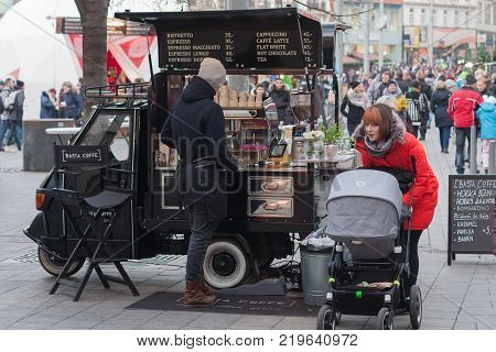 Brno,Czech Republic-December 18,2017: Woman is buying a drink at a mobile drink van at Christmas market at Liberty Square on December 18, 2017 Brno, Czech Republic