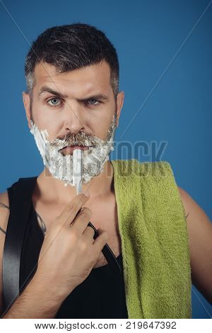 Barber and hairdresser. Man cut beard and mustache with razor and shaving gel. Haircut of bearded man archaism. Serious hipster in barbershop new technology. Fashion and beauty innovation.