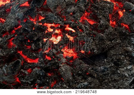 Lava flame on black ash background. Formation geology nature environment. Danger hazard energy concept. Volcano fire crust. Magma textured molten rock surface.