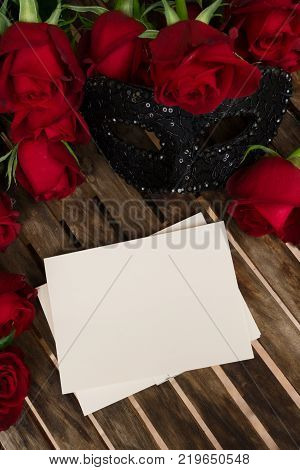 Valentines Day date invitation with roses and lacy masque, copy space on empty card