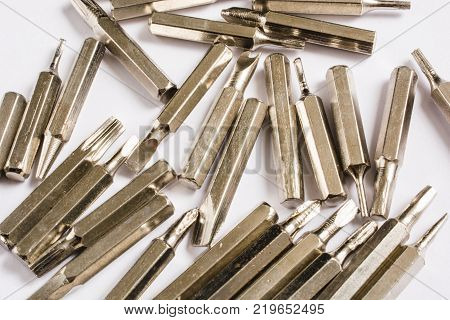 different bits for screwdrivers scattered on white background