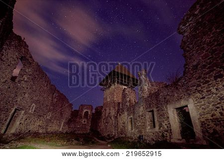 Ruins of Nevitsky Castle near Uzhgorod, Ukraine with a lot of shiny stars on the dark blue sky