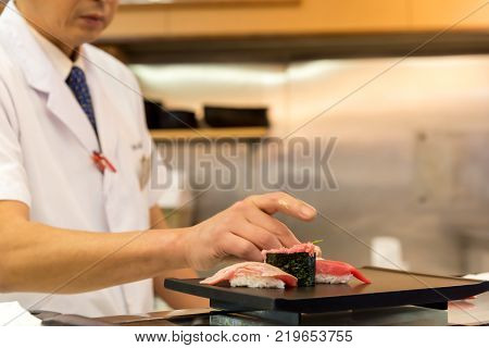 Chef making Sushi on the plate in a Japanese restaurant.