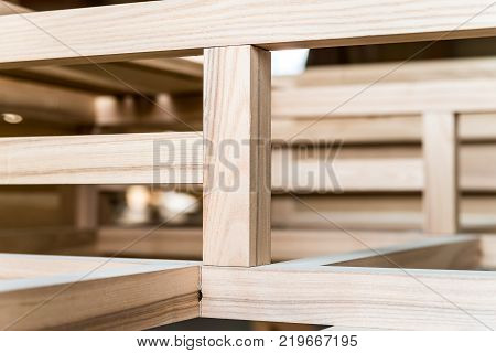 Close up image of newly made wooden beams attached to each other in carpenter's workshop