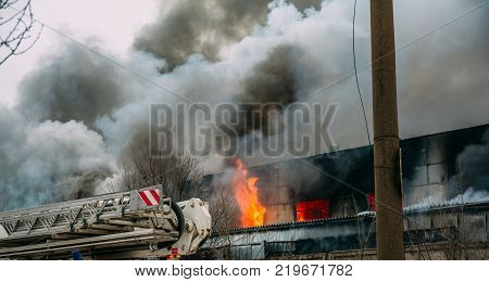 Fire in an industrial warehouse or Factory on Lantenskaya Street in Voronezh, rubber is burning, lots of smoke and flames, firefighters and MES rescue workers are struggling with a fire