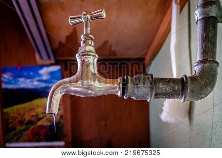 A frozen kitchen water crane in a uncultivated Swiss mountain hut. There has been no heating for a while and that is why the icicle is coming out of the crane.