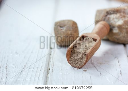 Asafoetida spice in wooden scoop on table