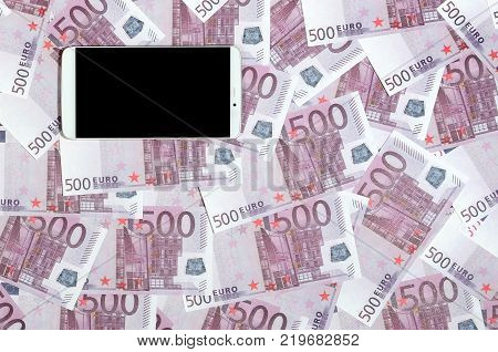 Purple 500 euro money bills and a smartphone with black screen. Copy space. The concept of online banking, money management and shopping with modern technology