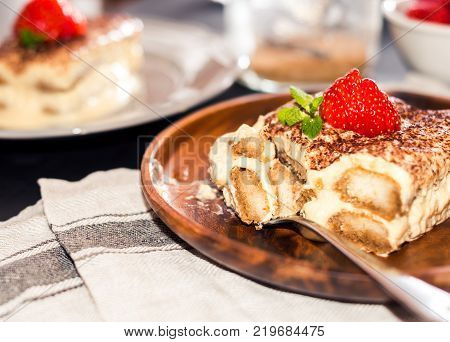 Homemade tiramisu cake decorated with strawberries Italian cuisine,
