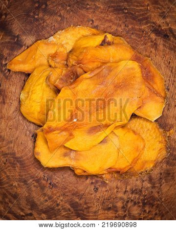 Unsweetened and unsulfured organic dried mango in wooden bowl