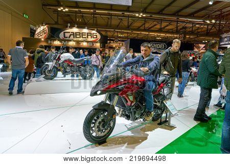 MILAN, ITALY - NOVEMBER 11, 2017: a visitor try out a motorcycle at the EICMA 2017 - 75th International Motorcycle Exhibition.
