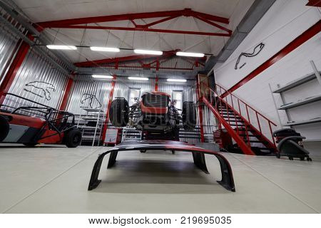 MOSCOW, RUSSIA - OCT 27, 2017: (PR) Technician works with racing car on wheeled rack based on Lotus Seven in garage of DB 527 company producer of russian sports cars .
