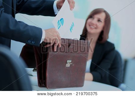 Cropped image of business woman getting documents out of briefca
