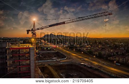 Aerial of crane looking over road and building sunset