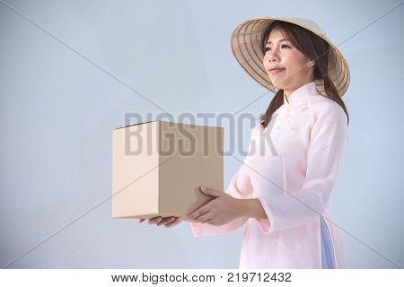 beautiful woman in pink dress and vietnam hat holding box