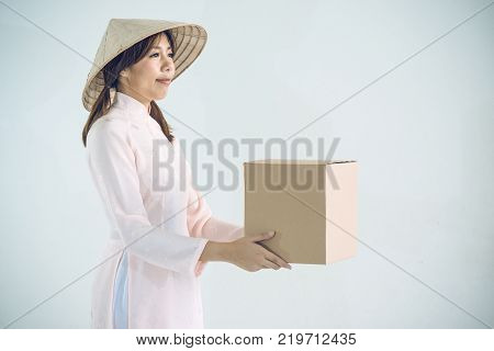 beautiful woman in pink dress and vietnam hat holding box