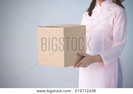 beautiful woman in pink dress and vietnam hat holding box