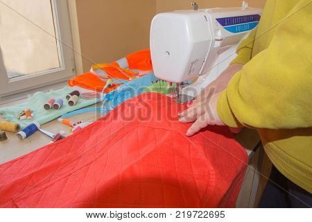 Tailor working at the studio. woman's hand sew cloth. Handmade. hands of female by needlework. Workplace of designer clothing close-up