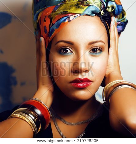 beauty bright african woman with creative make up, shawl on head like cubian woman closeup