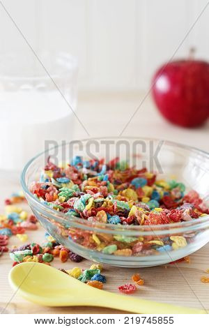Colorful rice cereal milk and red apple. Healthy quick breakfast. Wooden background. Copy space. Vertical. Selective focus.