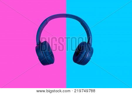 Top view on blue wireless headphones on vivid color background. Flat minimal style. Design and colors