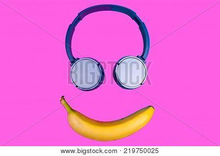 Pop art flat concept of banana and headphones on vivid colored background forming a smile face. Flat style and colors