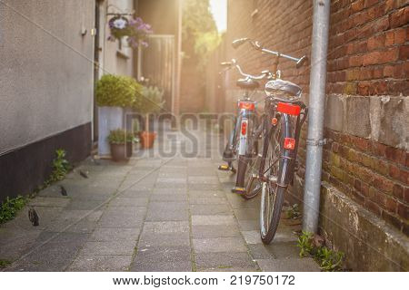 Two bycicles near stone wall on the old street.