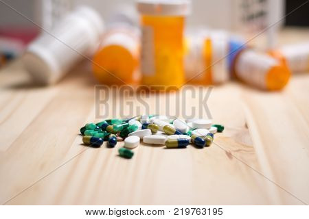 assortment of pharmacutical drugs with pill bottles in the background.