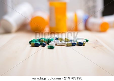 assortment of pharmacutical drugs with pill bottles in the background.
