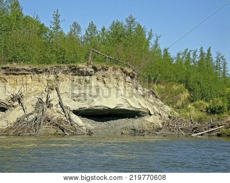 Crumbled cliff on the river bank. Clayey shore.