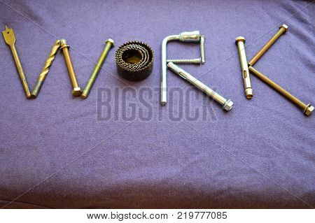 The inscription work is written by metal anchor bolts screws svermami wrenches. Work made up of objects. The word work is made up of a metalwork tool on a purple background.