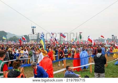 KRAKOW POLAND - 2016: Krakow Blonia World Youth Day pilgrimi in raincoats listen to the Pope the rain