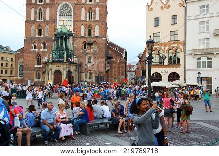 KRAKOW POLAND - 2016: Krakow main square a crowd of people two girls are doing selfie