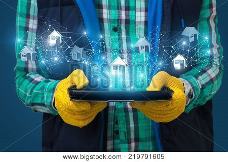 Builder shows on a tablet the network of houses on a blue background.