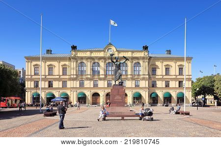 Karlstad Sweden - August 15 2013: View of the main square with people and the old town hall behind the peace monument Freden during a sunny day with clear blue sky.