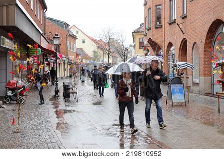 Ystad Sweden - April 15 2017: The Easter decorated shopping street Ostra Storgatan during rain.
