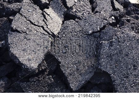 Broken up asphalt surface in a dark color