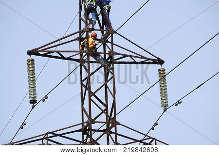 Silhouette electrician work installation of high voltage in high voltage stations safely and systematically over blurred